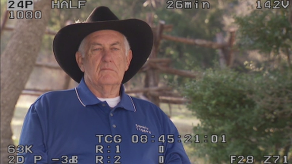 Monitor playback of a rancher in a cowboy hat, exterior interview