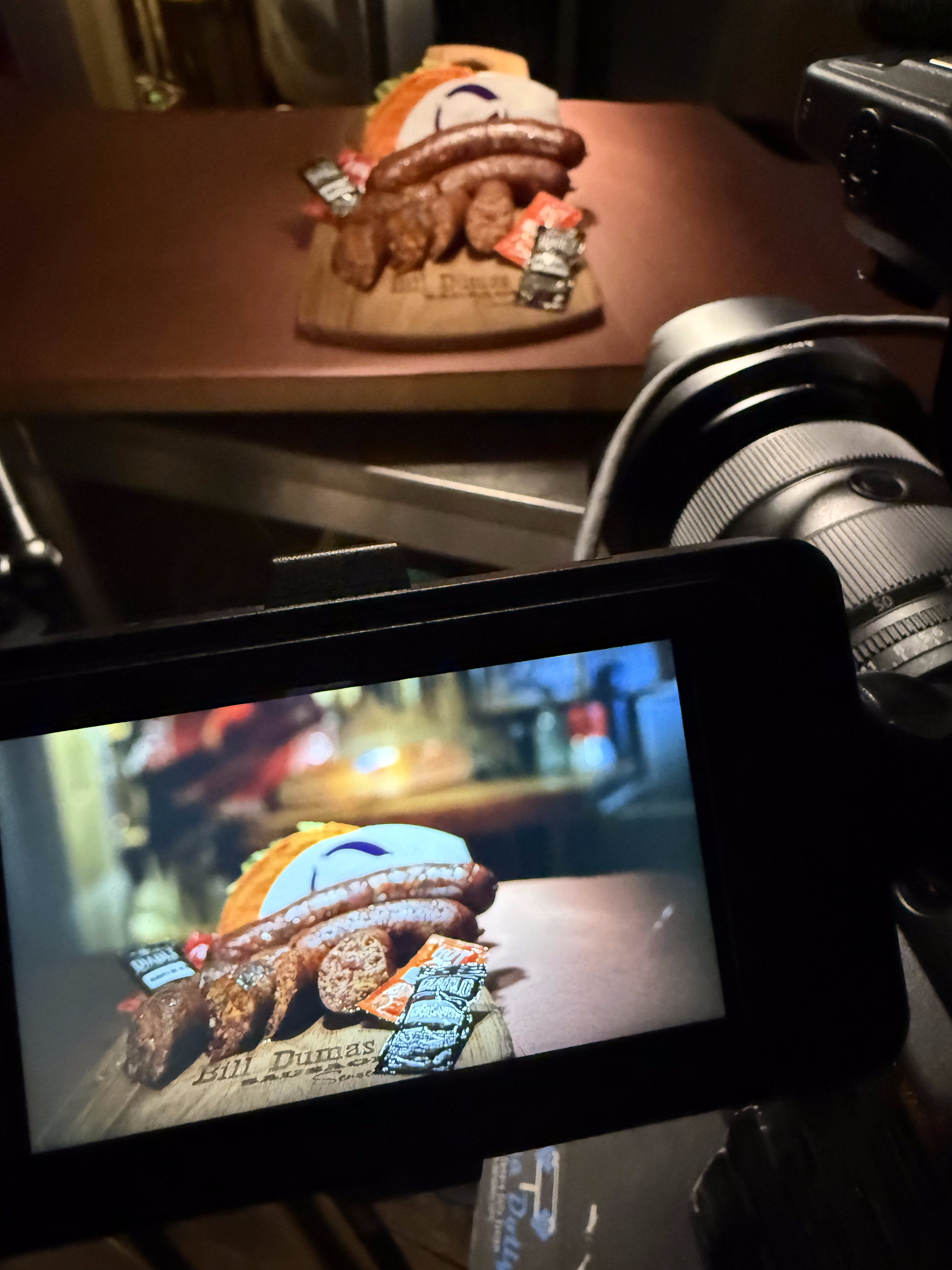 Camera monitor showing a product shot of a sausage sandwich on set