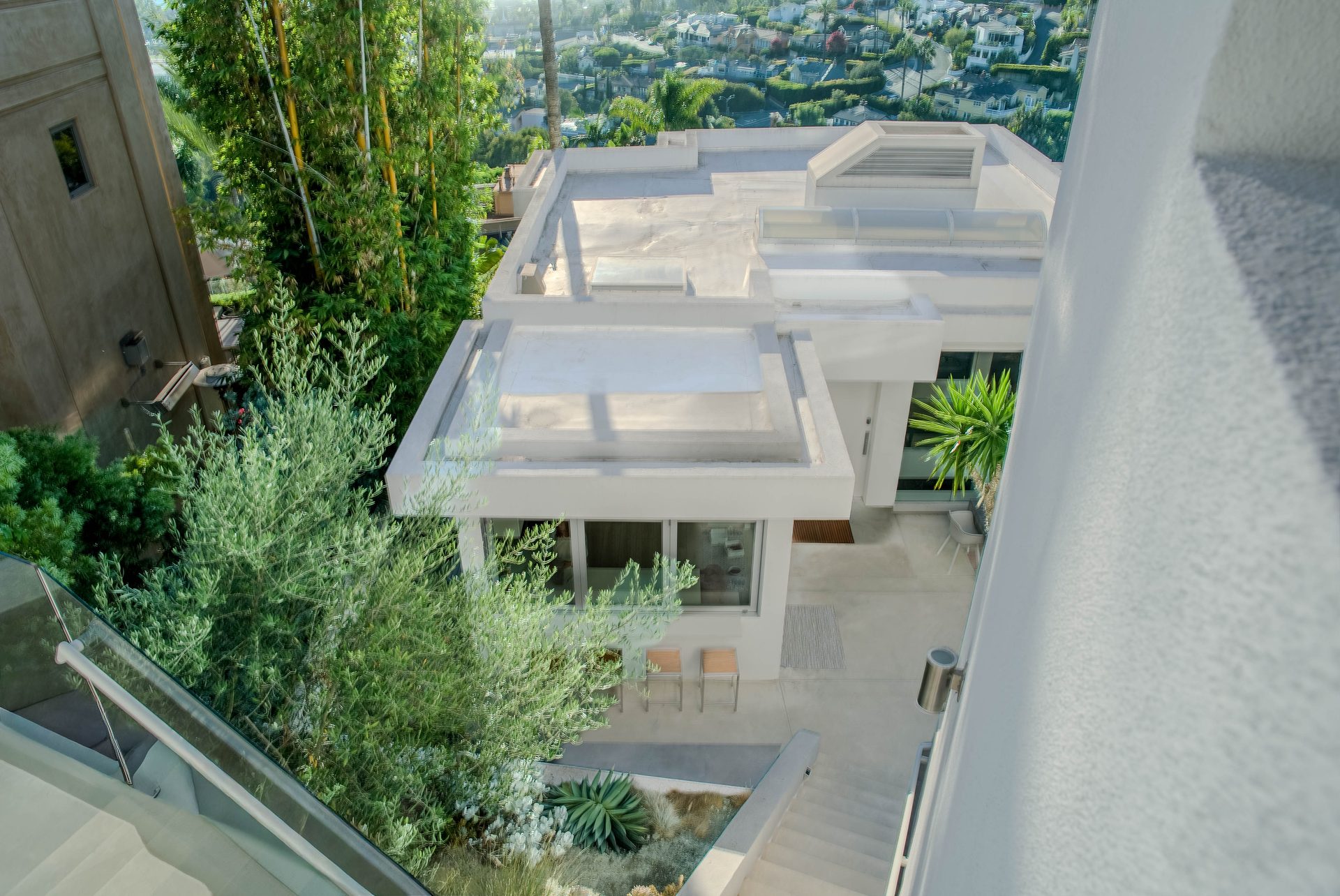 Aerial view of rooftop patio, skylights, and coastal hillside