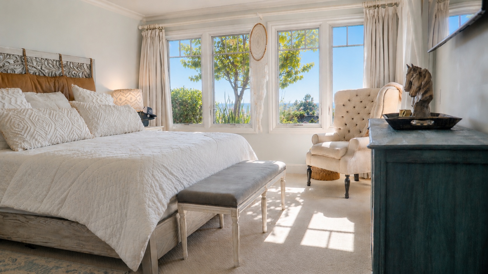 Primary bedroom with ocean view through windows