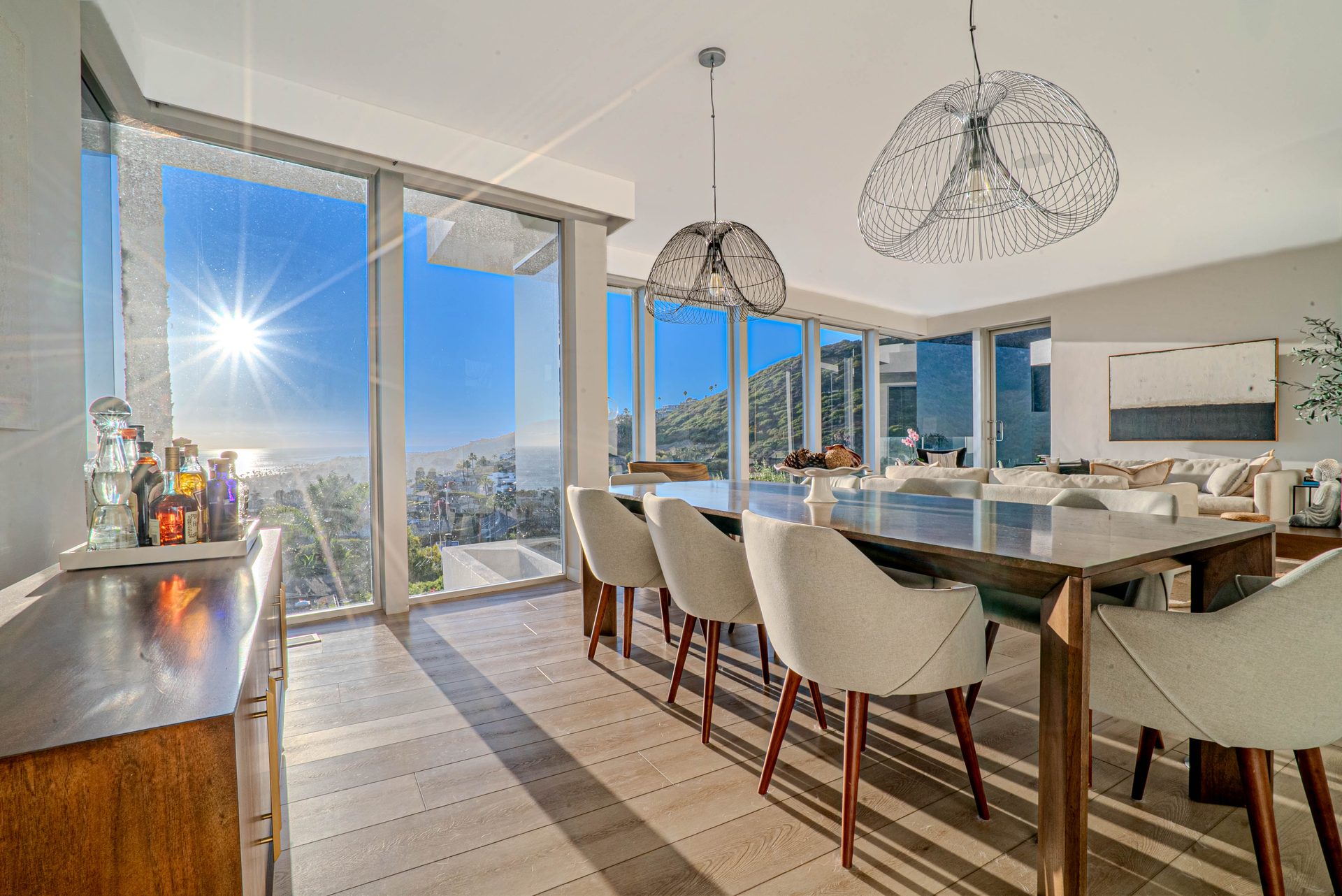 Dining and living area with wire pendant lighting and ocean view