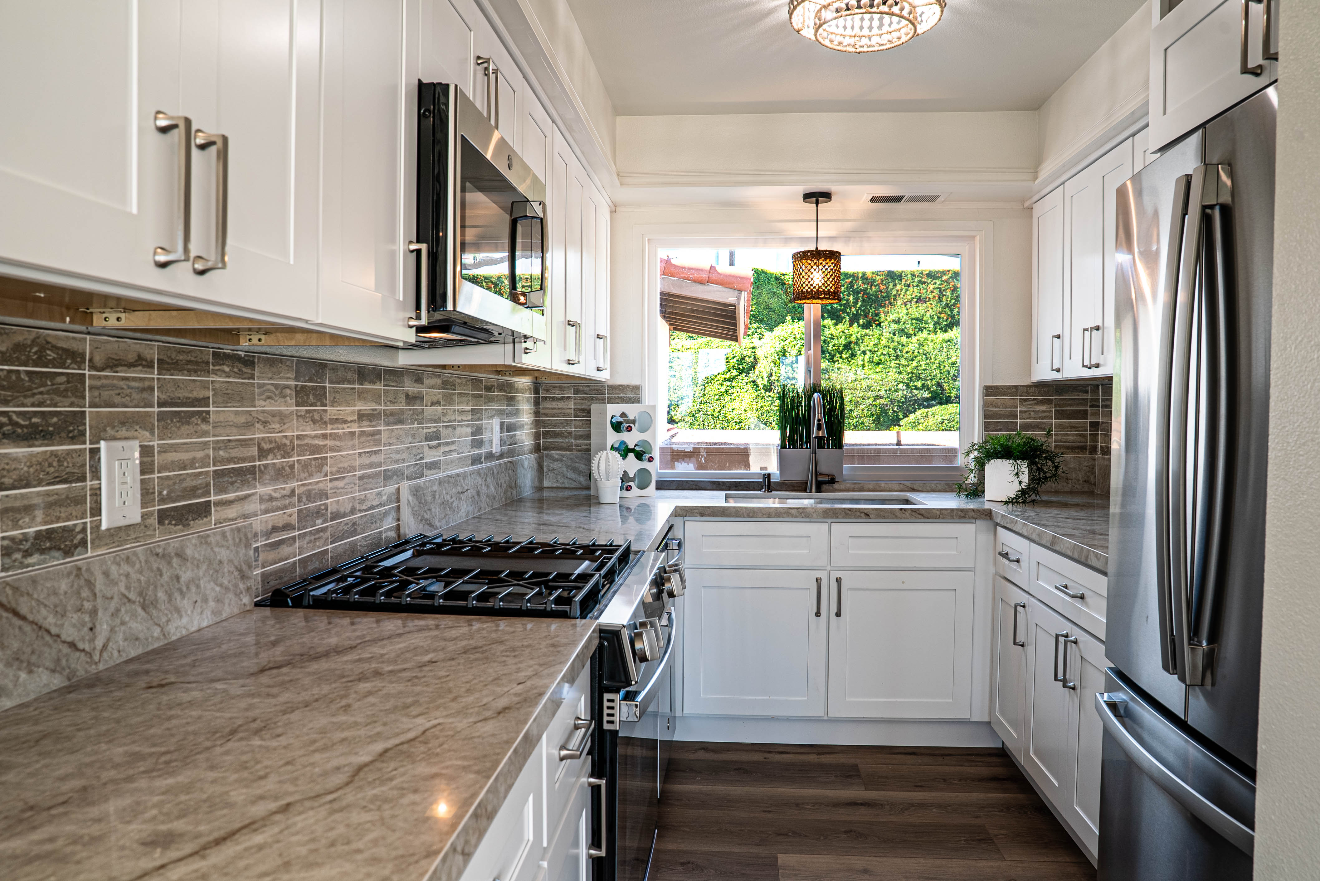 Galley kitchen with white cabinetry and stone countertops