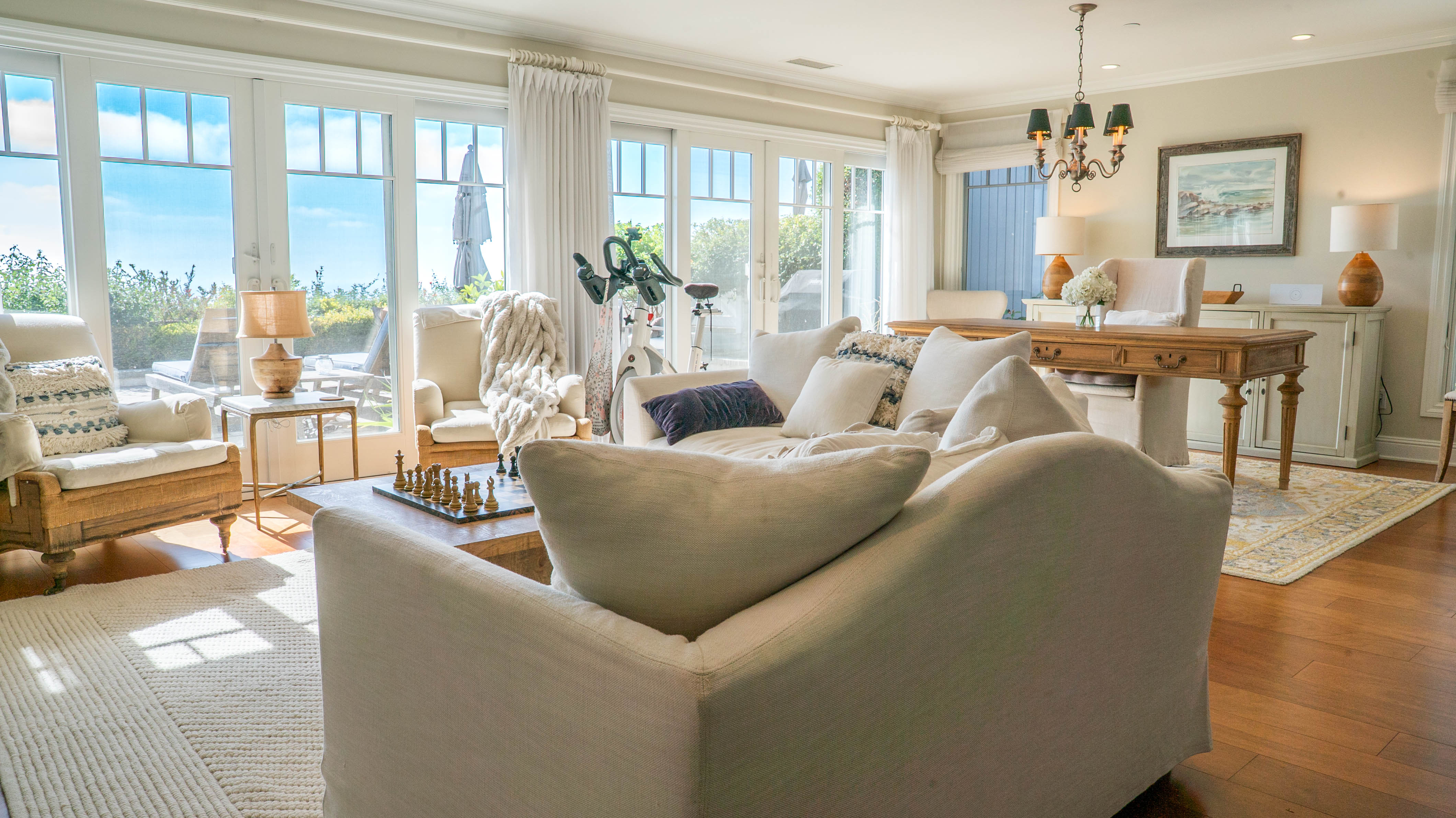 Bright living room with French doors, ocean view, and cozy furnishings