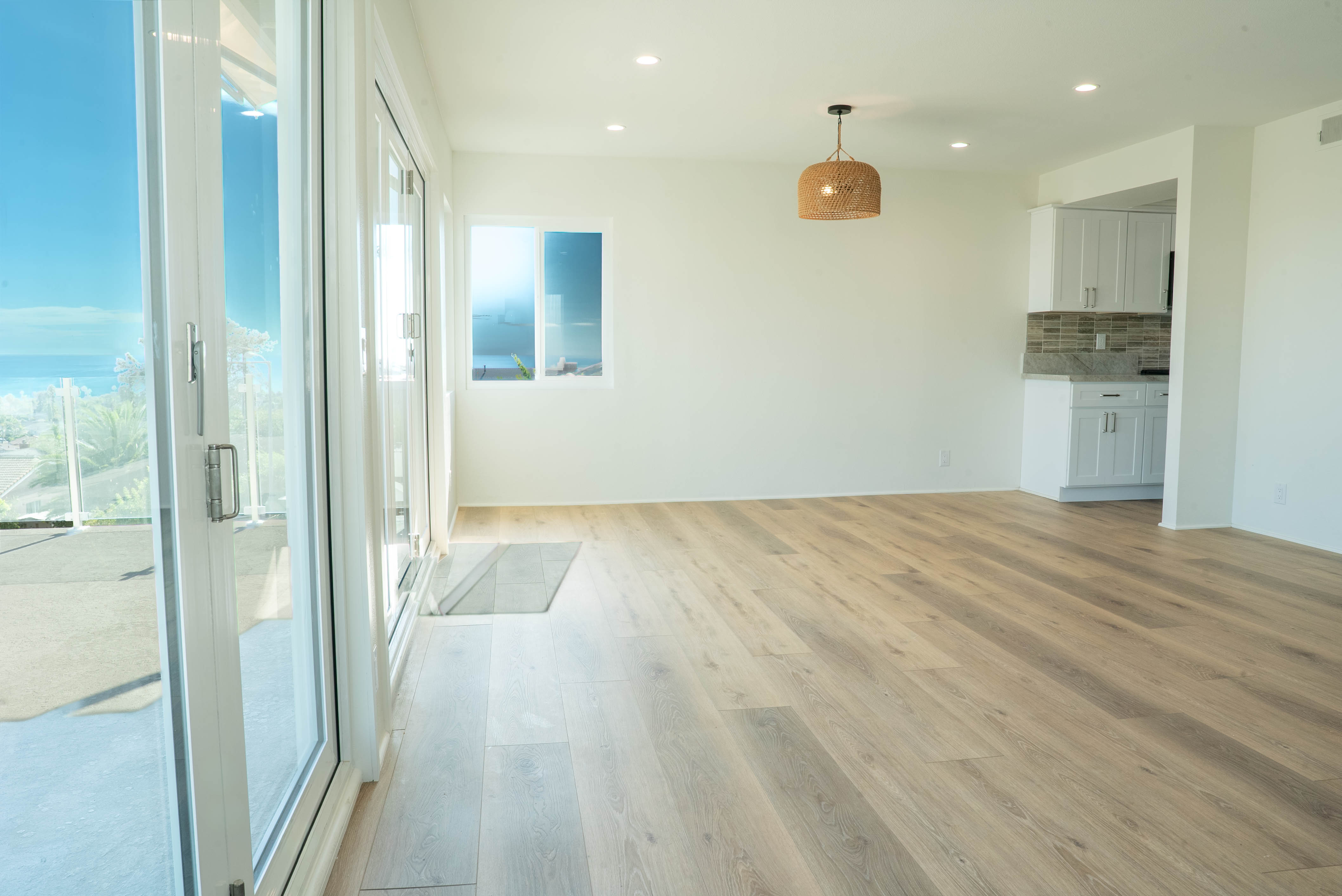 Bright living room with sliding glass doors open to an ocean-view patio