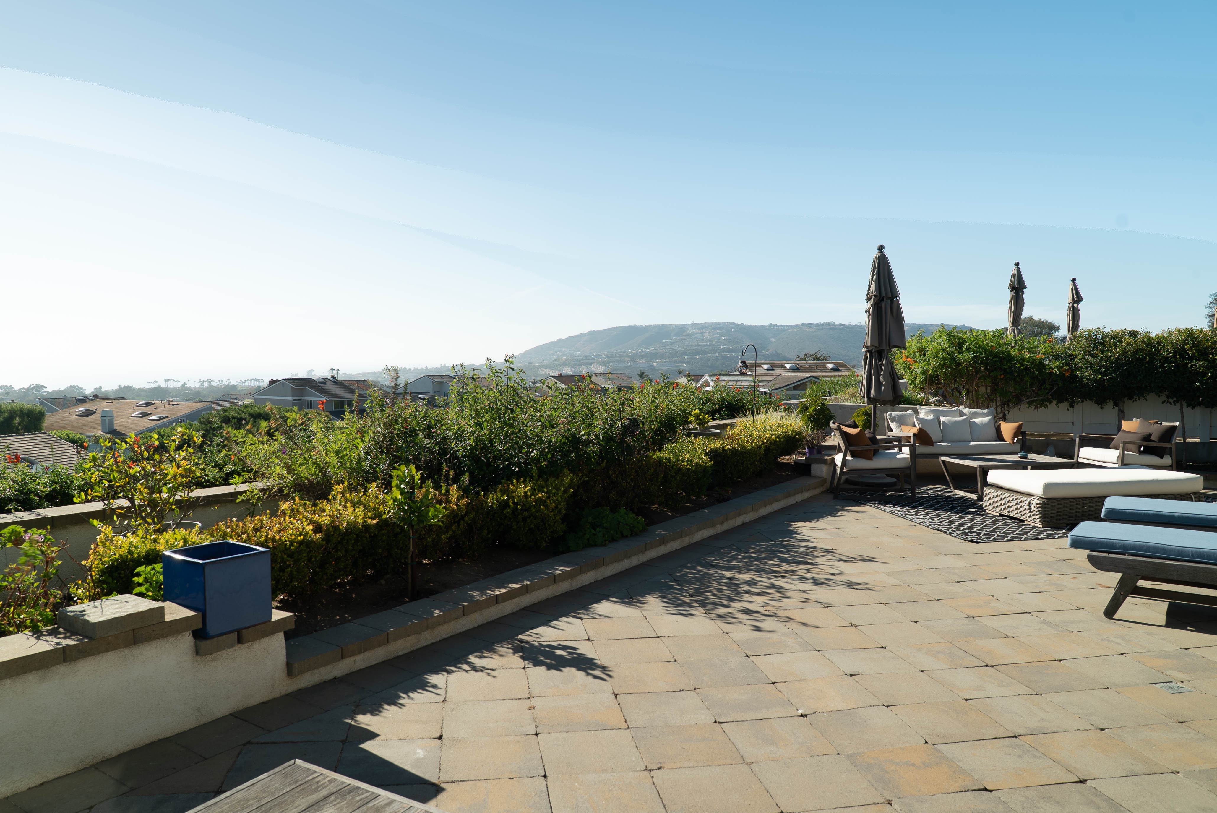 Rooftop patio seating area with hillside view