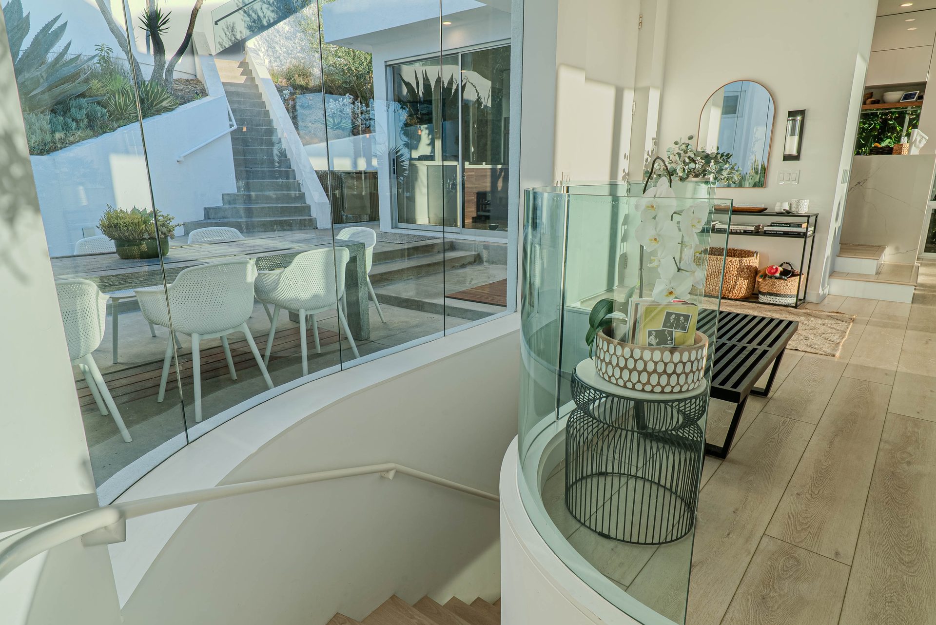 Curved glass stairwell overlooking the outdoor patio