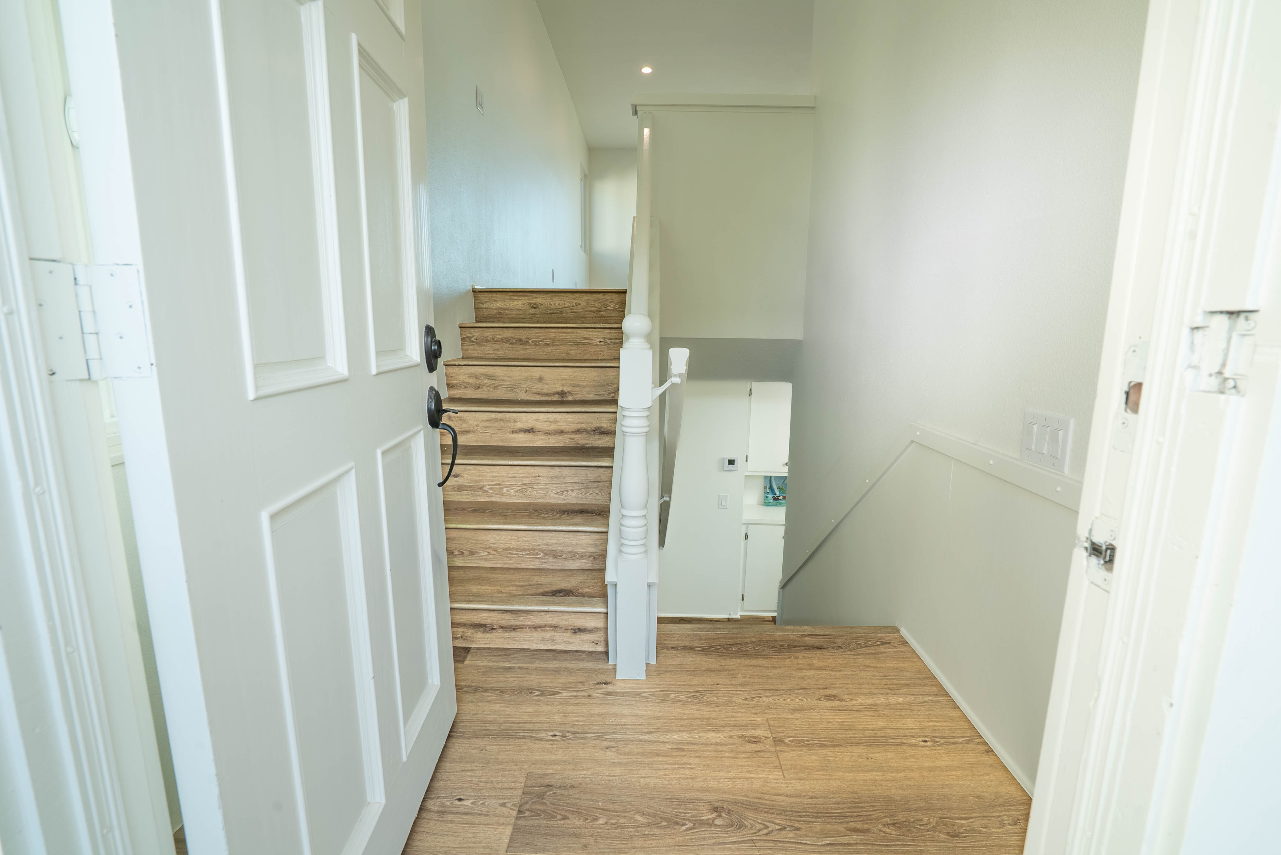 Wood staircase with white railing leading to the upper level